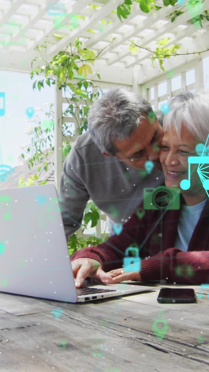 Animation of networks of connections spinning over senior couple using laptop at home