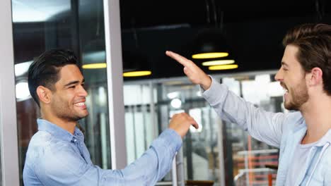 ejecutivos masculinos dándose el "high-five" el uno al otro