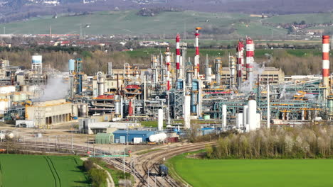 verdant fields with a train passing by alsachemie plant, neuenburg backdrop, daytime