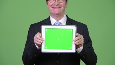 un hombre de negocios muy guapo mostrando una tableta digital.