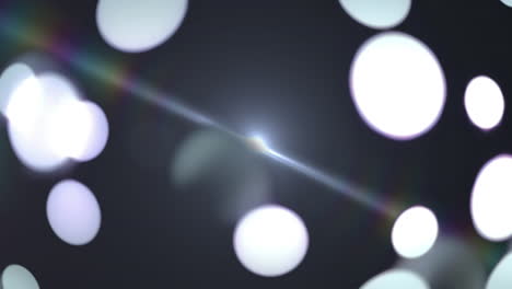 white glowing spots of light and lens flare against black background