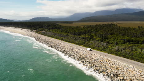 aérea sobre la carretera de la costa a lo largo de la bahía de bruce en el sur de westland, isla del sur, nueva zelanda, drone dolly tiro hacia adelante