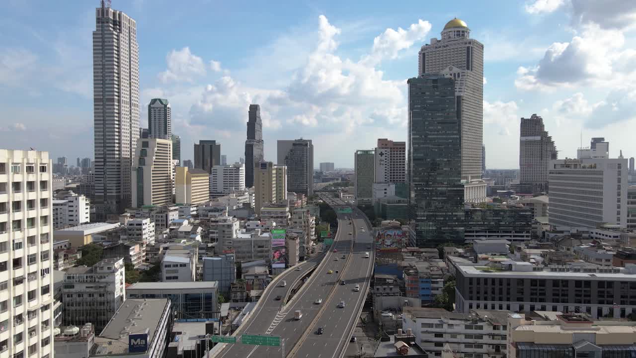 Aerial View of Highway Crossing in Bangkok City Surrounded by Urban Buildings and Traffic Flow