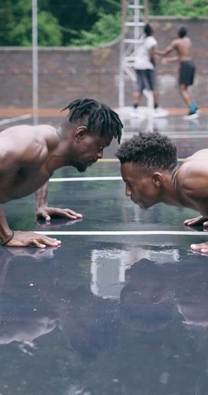 Two Athletic Men Doing Pushups and High-Fiving on Outdoor Basketball Court