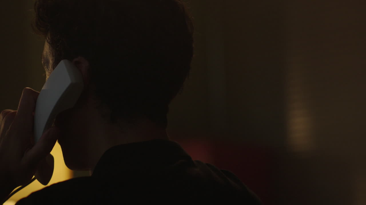 Person Talking on a Vintage Phone in Low Light