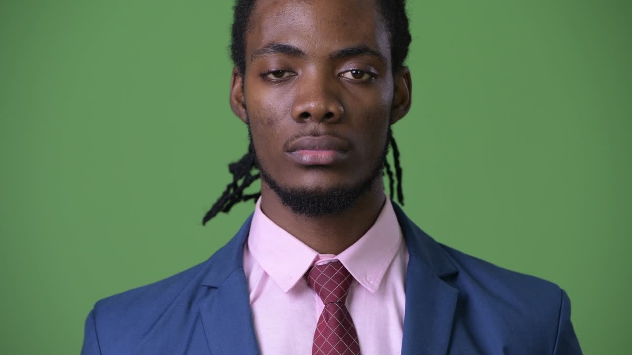 молодой красивый африканский бизнесмен с дредами на зеленом фоне