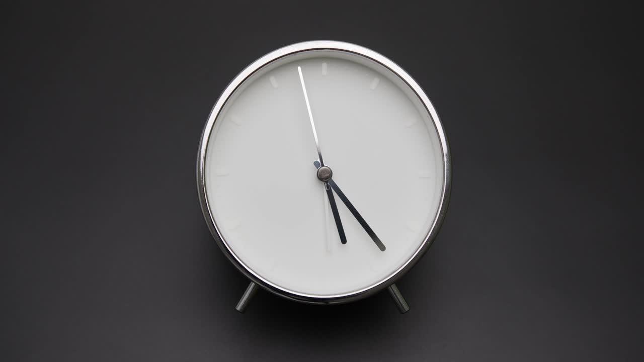 Orologio d'argento isolato su sfondo nero, il tempo inizia a scorrere alle 5 in punto