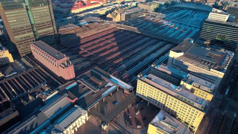 aerial drone shot flying over oslo central train station near opera gate, oslo cityscape in norway during evening time