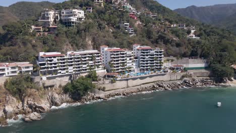 Mismaloya-Beach-The-colorful-Sierra-Madre-Mountains-meet-the-serene-waters-of-the-Mexican-Pacific-Ocean-at-the-beach-of-Mismaloya,-a-quaint-fishing-village-just-15-minutes-south-of-Puerto-Vallarta