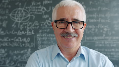 smiling teacher in front of a chalkboard