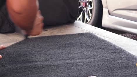 person loading luggage or cargo on a wooden platform of a car.