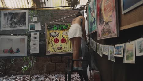 hermosas obras de arte cuelgan en las paredes, y una chica trabaja en el fondo