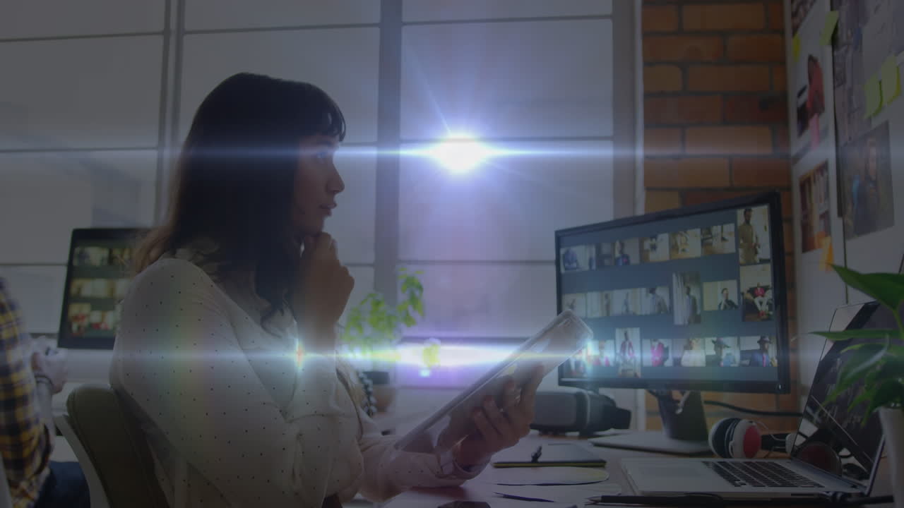 Animation of light trails over caucasian businesswoman using tablet