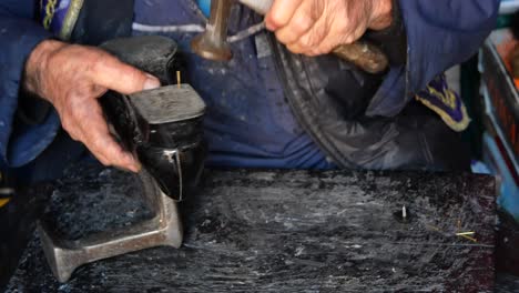 a cobbler repairs a shoe