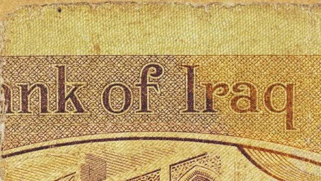 macro pan across an iraqi banknote, revealing the “central bank of iraq” text