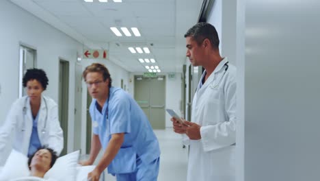 Medical-team-pushing-emergency-stretcher-bed-in-the-corridor-at-hospital