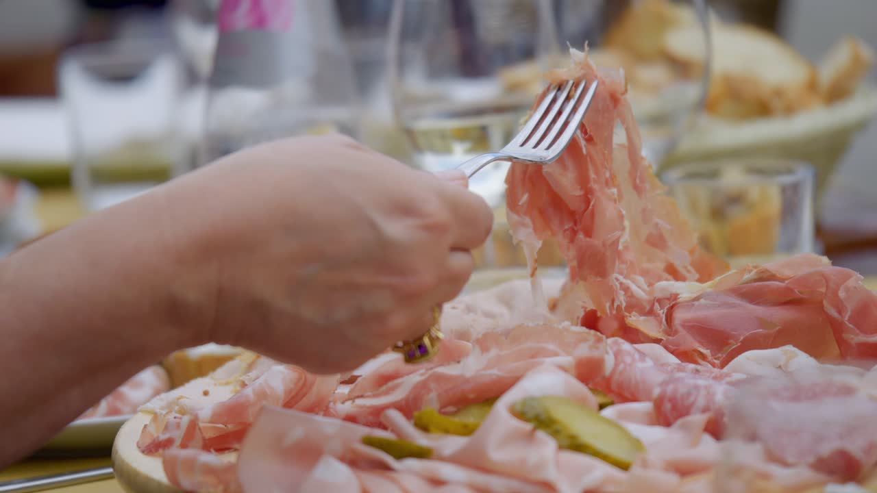 Close up Of Person Hand Wearing Gold Ring Choosing Food From Fresh Cold Cuts Plate