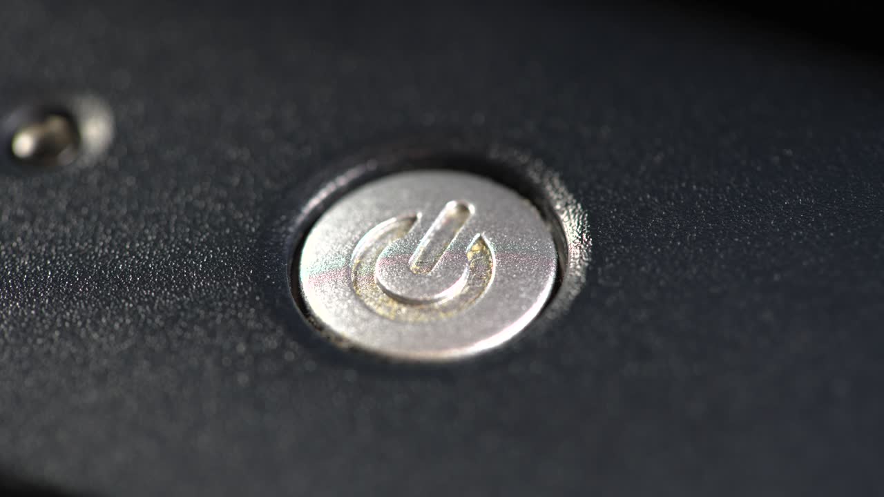 손가락으로 전원 버튼을 누르면, 노트북 컴퓨터를 켜는 사람, 간단한 전기 장치에 전력을 공급하는 사람, 객체 세부 사항, 매크로, 극심한 클로즈업. 시작, 부팅 개념, 전력 상징