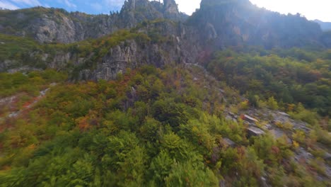 drone flight up a mountain covered in beautiful autumn coloured trees in theth, albania