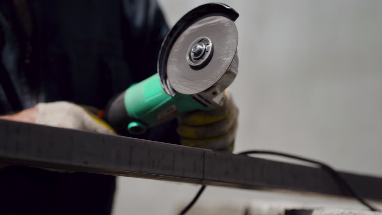 남자는 원형 도자기를 니다. 뜨거운 금속에서 불꽃이 날아갑니다. 남자는 열심히 일합니다.