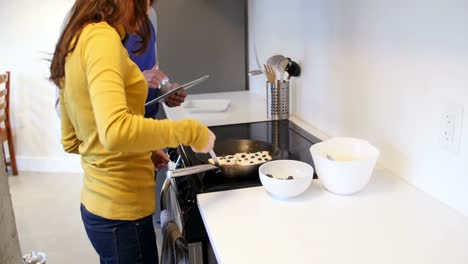 Woman-preparing-grapes-tart-in-kitchen