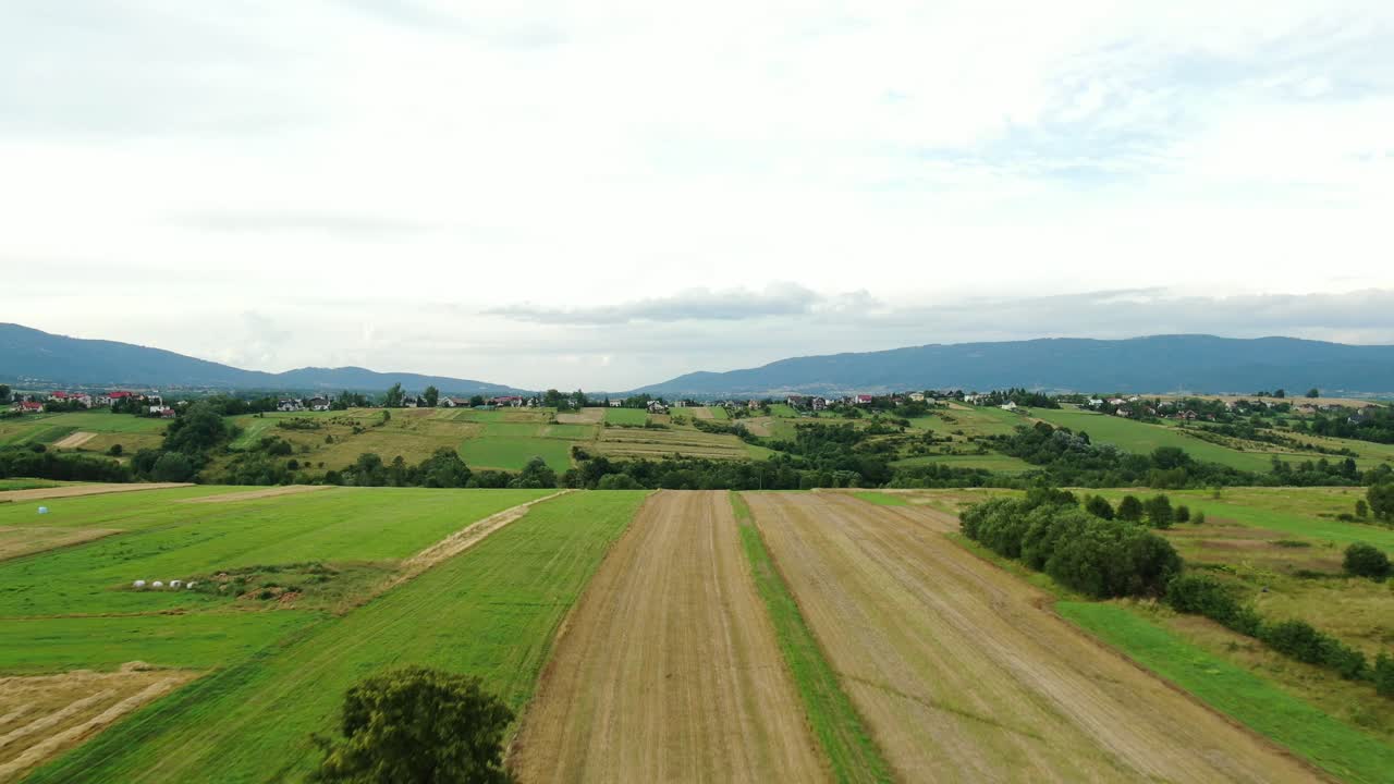 toma aérea de campos con montañas en el fondo día nublado