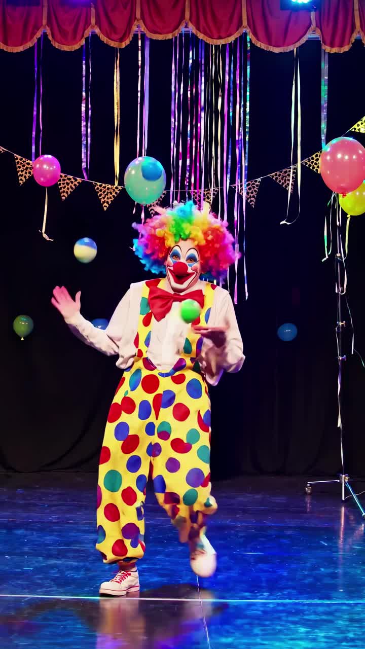 A colorful clown performs on stage with balloons and streamers