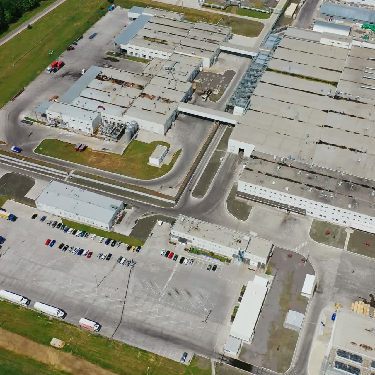Modern production plant. View from above on manufacture area on field. Exterior of new large industrial complex. Top aerial view.