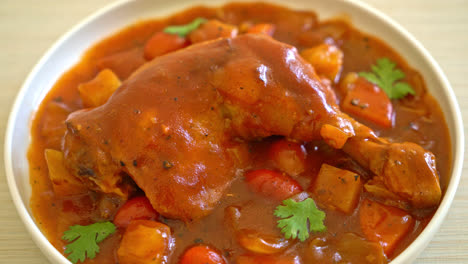 estofado de pollo casero con tomates, cebollas, zanahorias y patatas en el plato