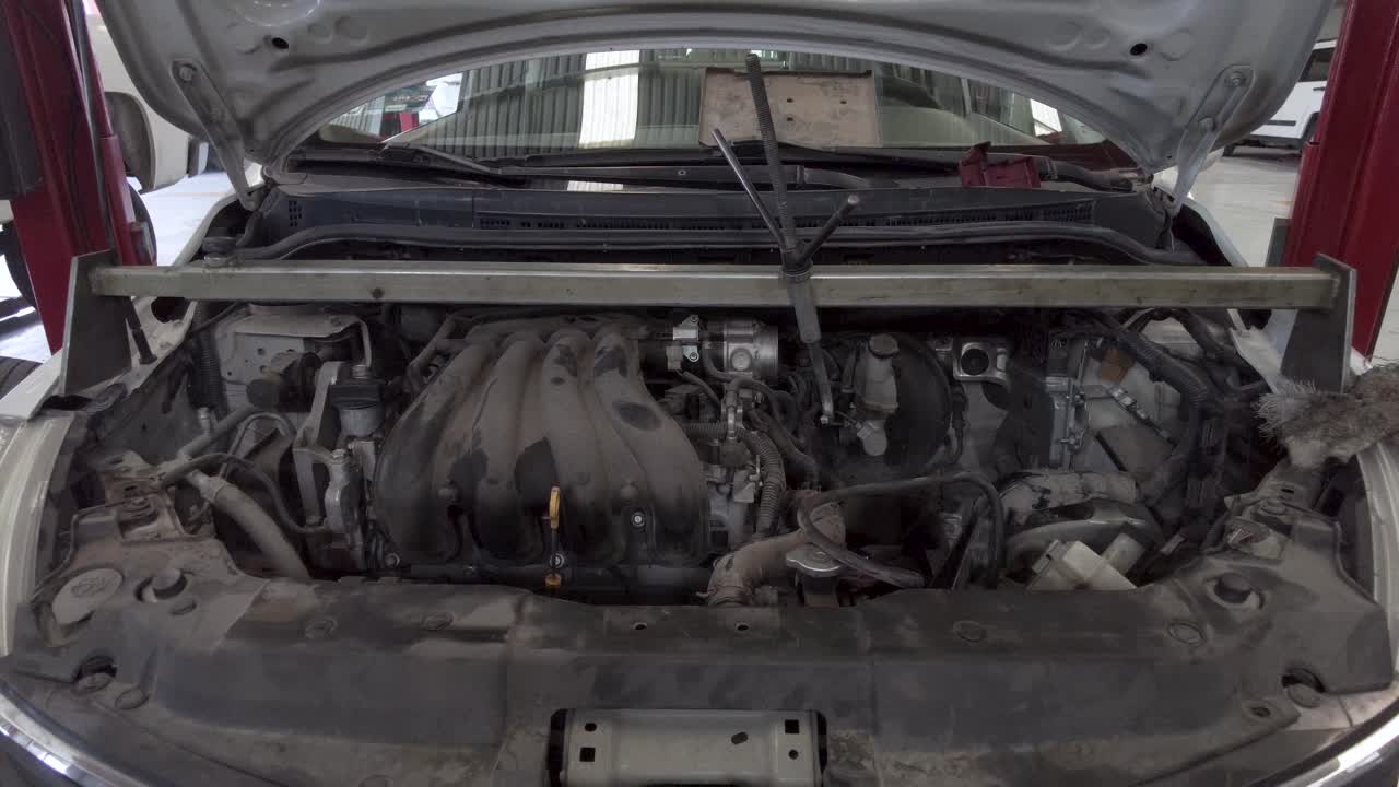 The front of a car with the hood up showing the motor engine for repair service at a workshop station garage at mexico latin-america