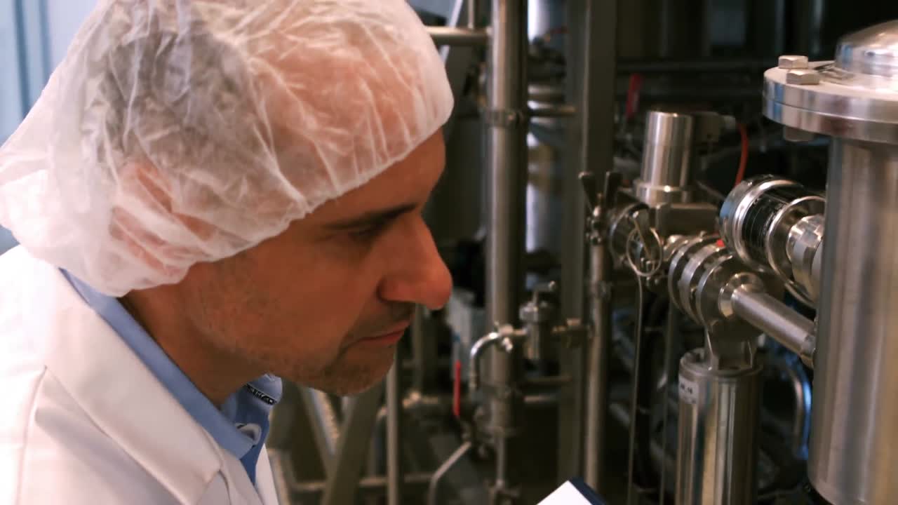 cervecero escribiendo en el clipboard en la fábrica de cerveza