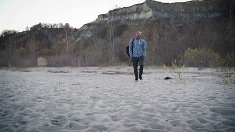 hombre atractivo caminando por una hermosa playa en cámara lenta