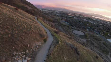 una impresionante toma fpv captura una impresionante puesta de sol y nubes dramáticas mientras se desliza por un camino que conduce al paraíso