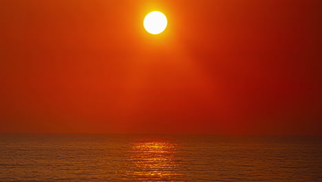 timelapse shot of the sun coming down over the horizon in the background over the ocean during evening time