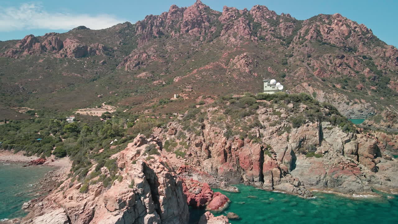 이탈리아 사르데냐의 맑고 푸른 바다가 내려다보이는 경치 좋은 산 꼭대기에 있는 기상 관측소 - 공중 드론 샷