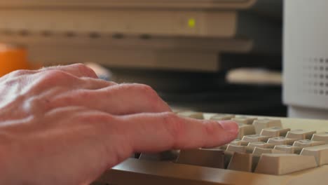 Man working and gaming on retro computer PC, IT engineer with vintage computer at home, using old fashion technology, close up of retro setup.