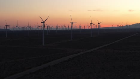 wind turbine farm with orange sunset skies