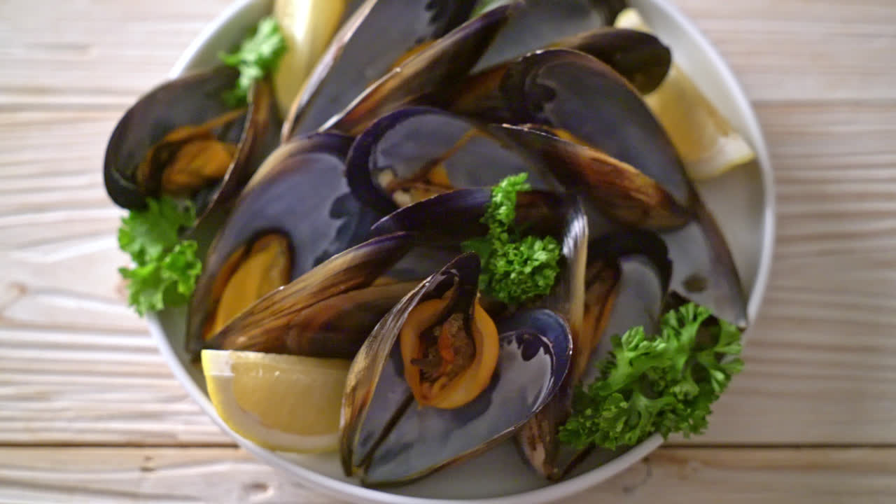 mejillones frescos con hierbas en un bol con limón