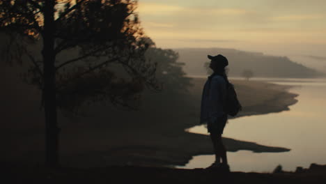 woman hiking at sunrise by the lake