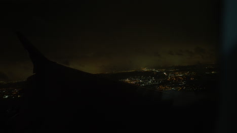 Blick-Auf-Die-Ferne-Nachtstadt-Vom-Fliegenden-Flugzeug-Aus