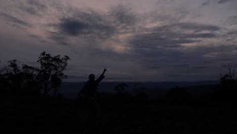 a mans silhoutte dancing to a sunset in the alpine mountains of australia