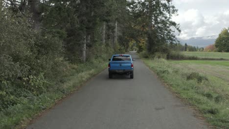 blue ram pickup truck driving along rural road