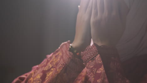 close up studio shot showing hands of muslim woman wearing hijab praying 2