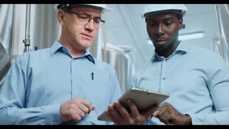 industrial engineers discussing project on a tablet
