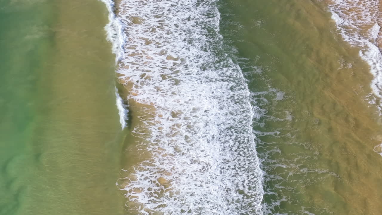 Close up flight over the waves and shallows of Queensland's iconic Rainbow Beach