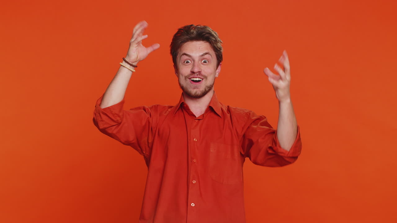 Uomo caucasico emozionato e stupito che si tocca la testa, mimando un’esplosione per celebrare un’idea geniale o una risposta esatta