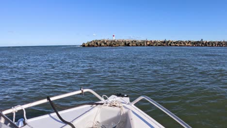 boat moving towards rocky shore in gold coast