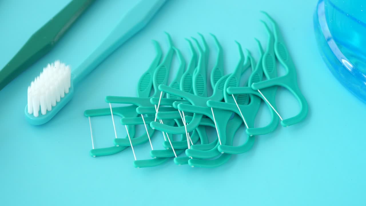 Dental Floss, Toothbrush, and Mouthwash on a Blue Background
