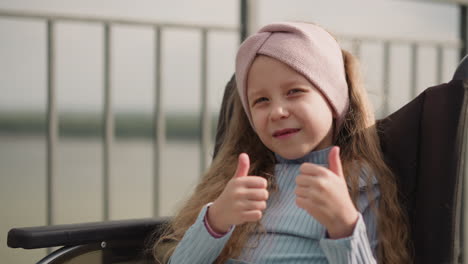 toothless girl smiles in camera showing thumbs up gesture