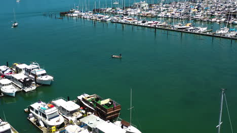 Vista-Aérea-Hacia-Un-Pequeño-Barco-Listo-Para-Salir-Del-Puerto-Deportivo-De-Sausalito,-En-El-Soleado-EE.UU.